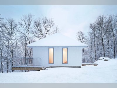 This Snow-White Cabin Disappears Into a Wintry Lakeside